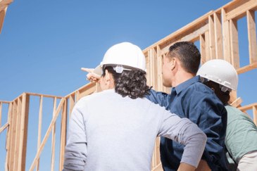 soft lighting, a man in a blue shirt pointing towards the construction, using communication as one of his soft skills 