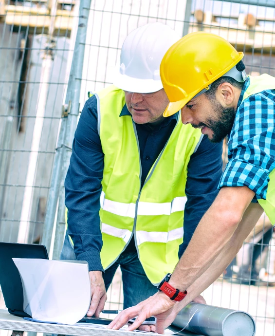 A construction developer and a member of his team reviewing reviewing plans.