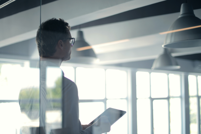 A man with a tablet looking at construction management software 